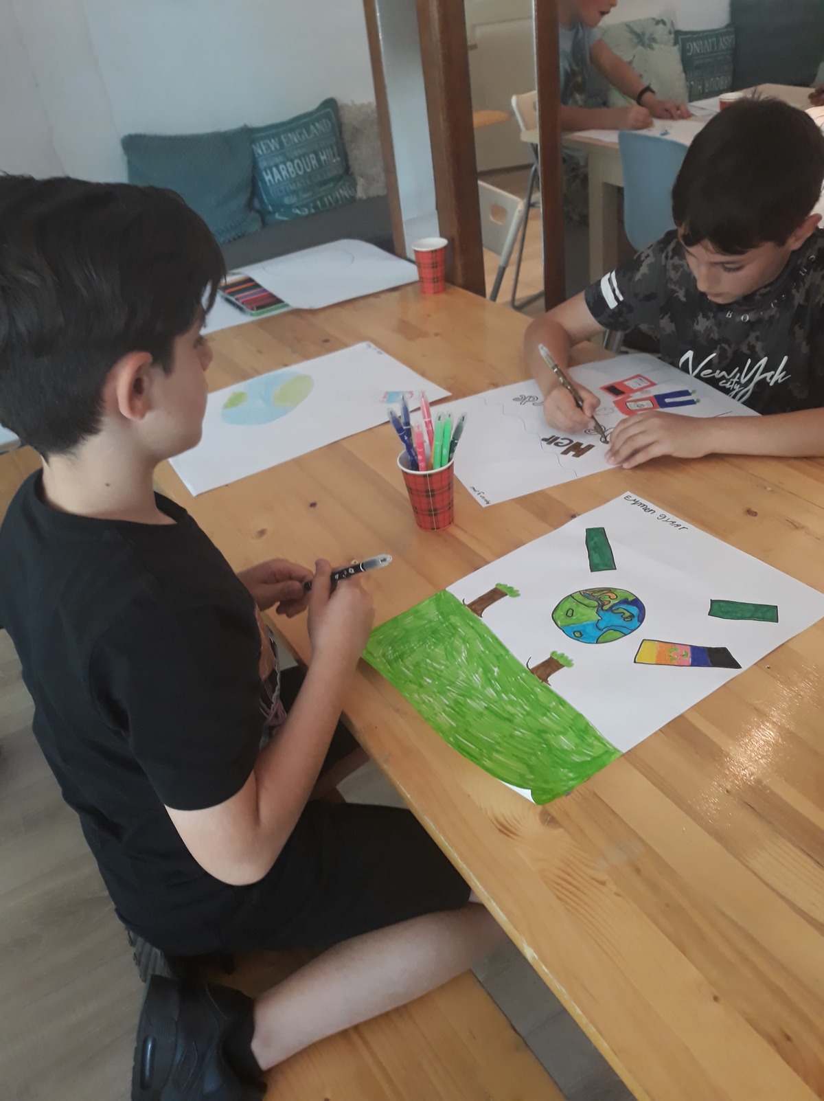 Kinderen maken een tekening voor de prullenbakkenkunst in Hofwijk