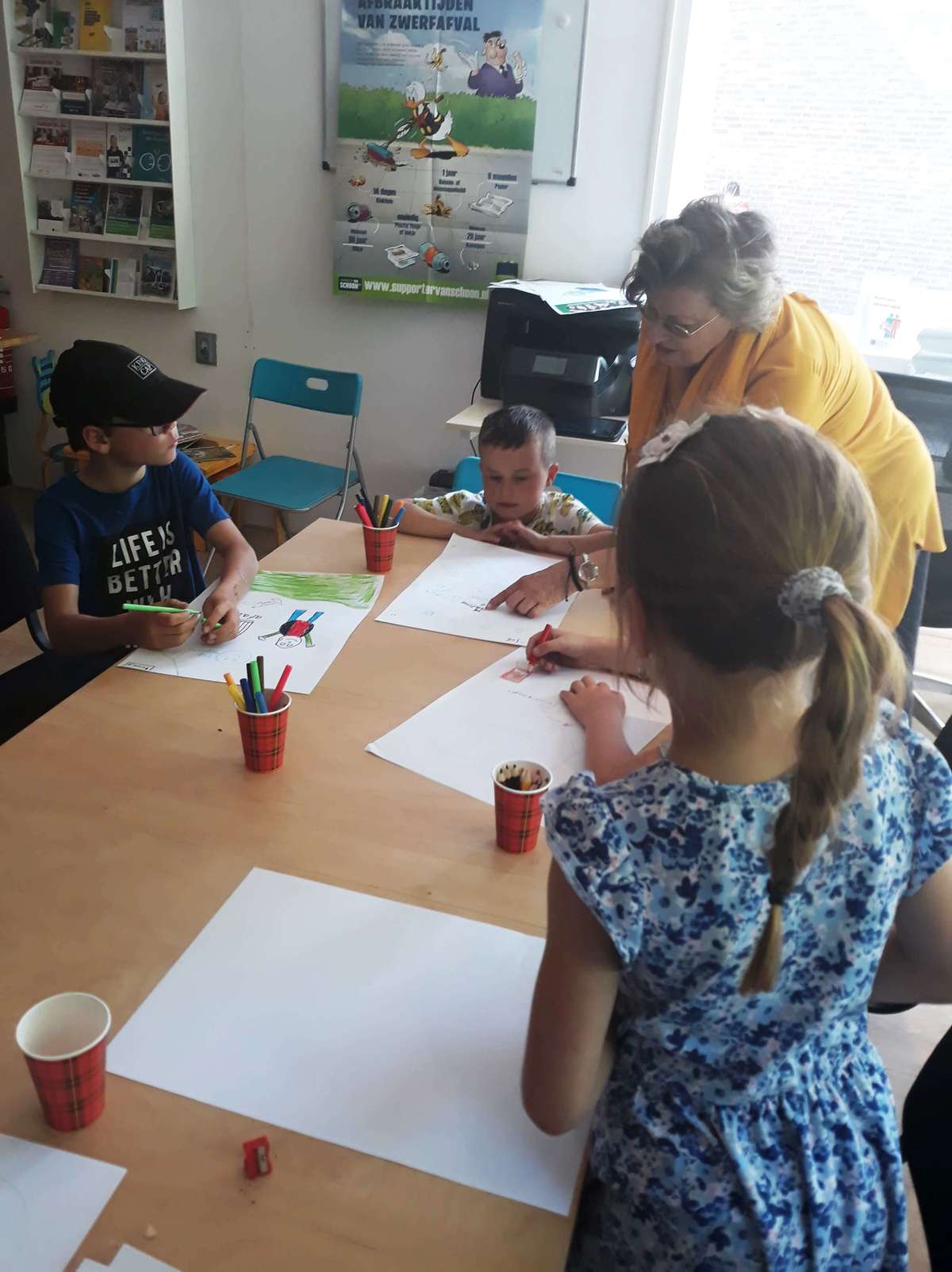 Kinderen aan het tekenen voor de prullenbakkenkunst in Hofwijk